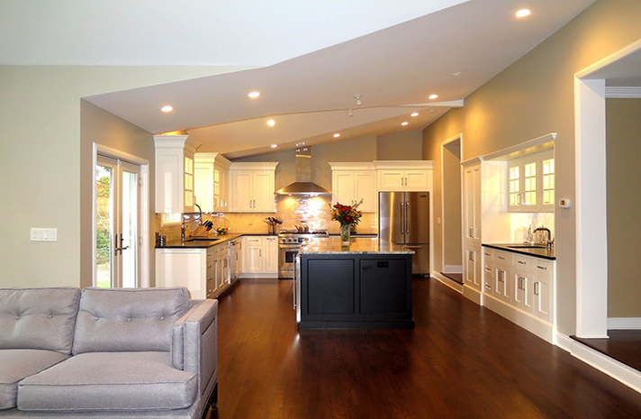 A living room with a couch and a kitchen in the background