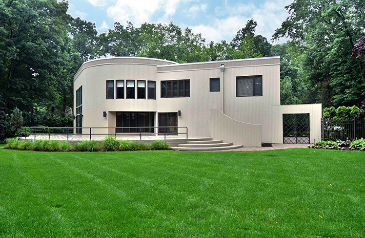 A large white house with a lush green lawn in front of it