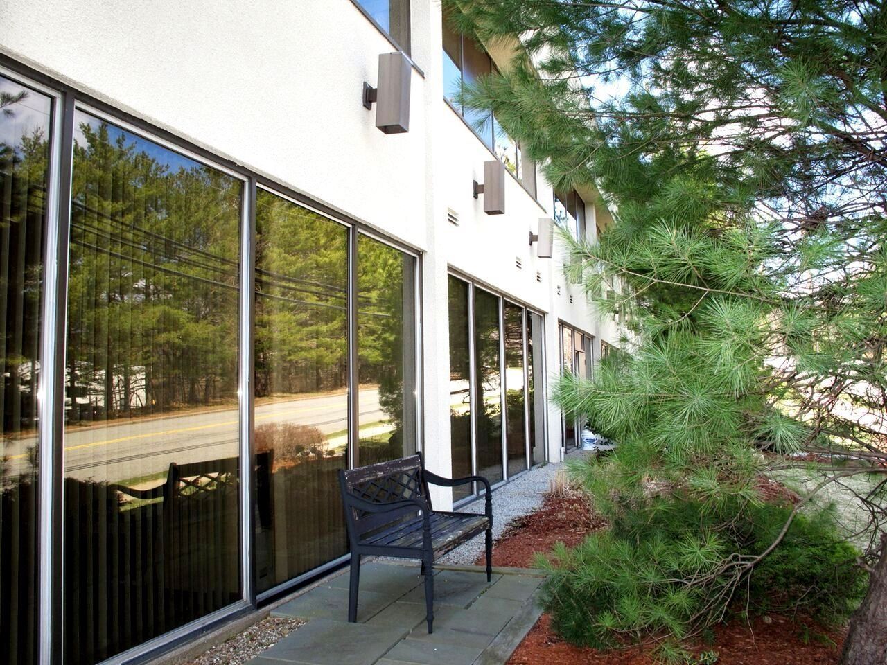 A bench sits in front of a building with lots of windows