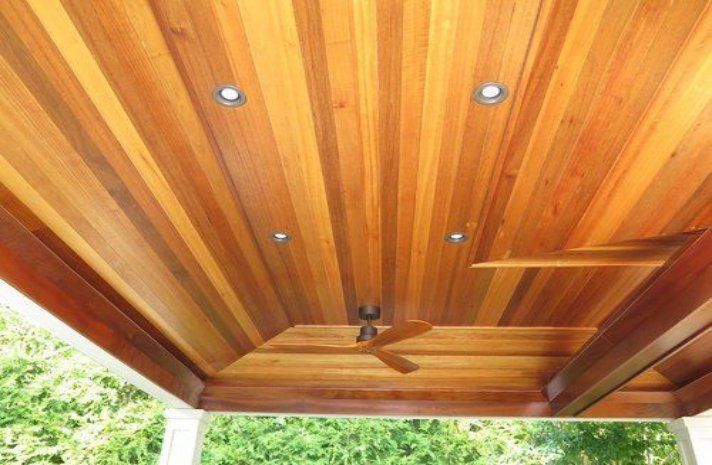 A wooden ceiling with a ceiling fan on it