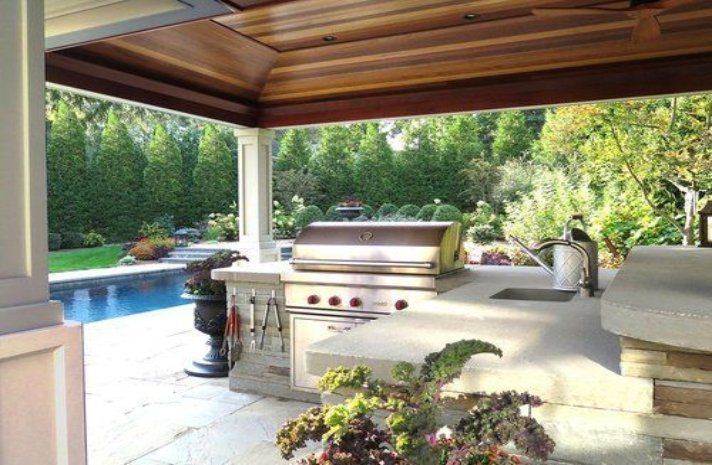 An outdoor kitchen with a grill and a sink
