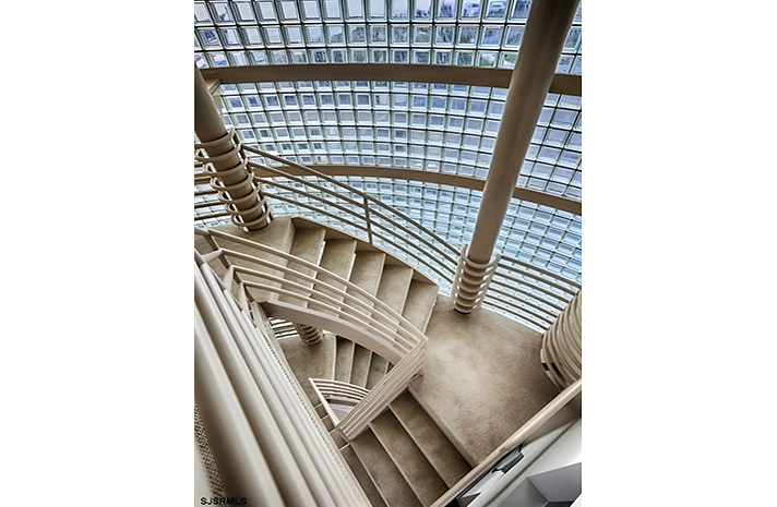 A spiral staircase in a building with a glass ceiling