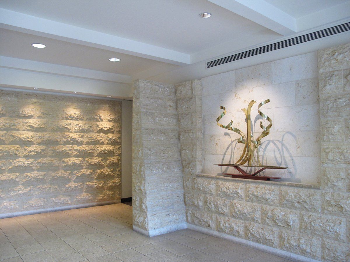 A room with a stone wall and a sculpture on the wall