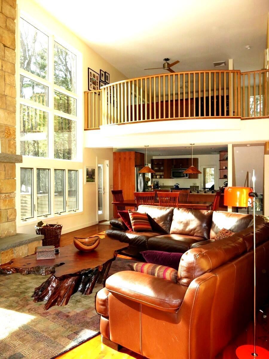 A living room with a couch and chairs and a balcony