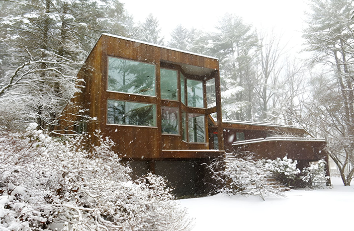 A wooden house in the middle of a snowy forest