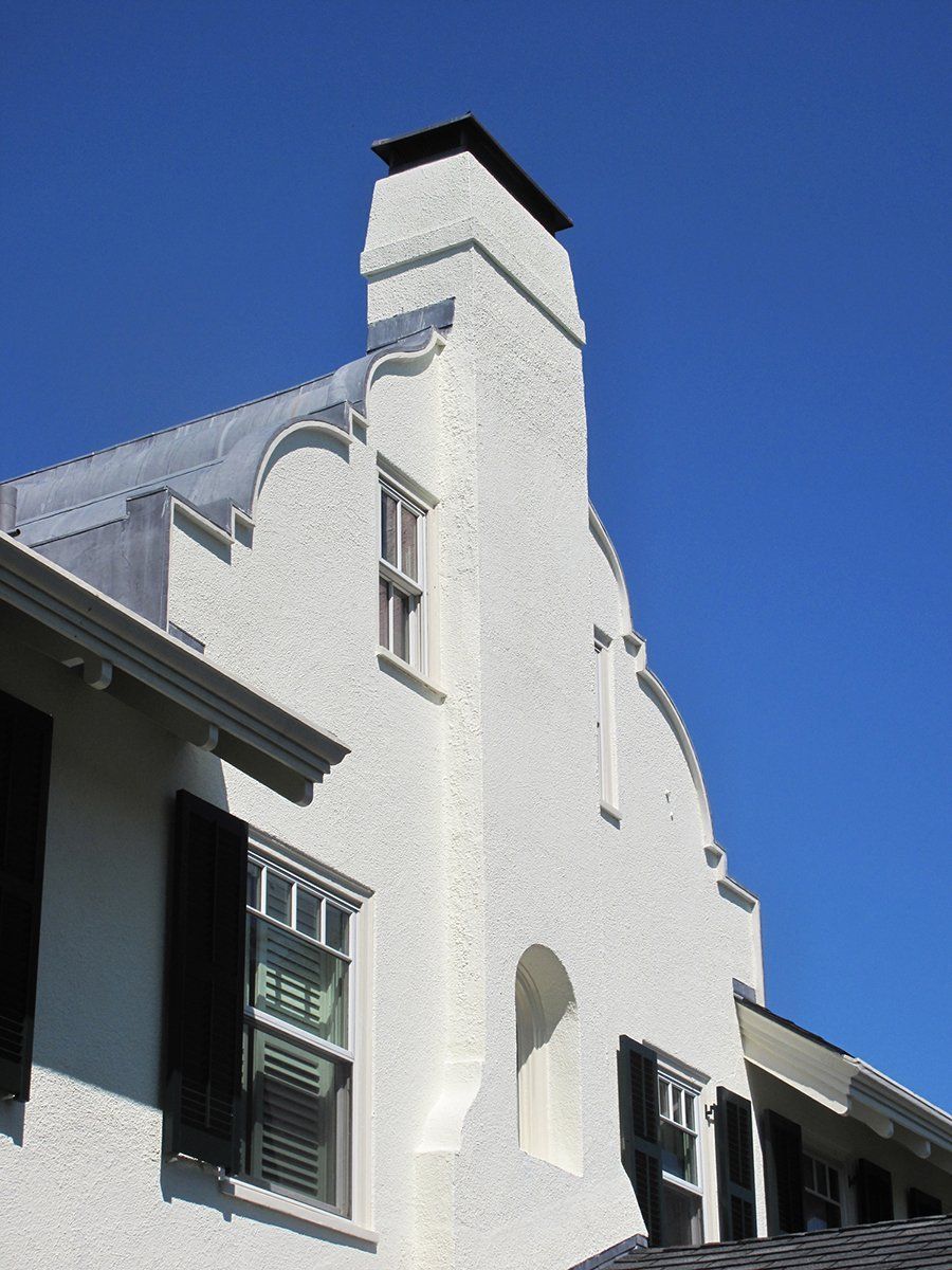 A white building with a chimney on top of it