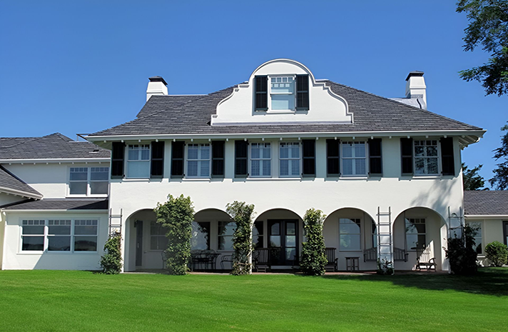 A large white house with black shutters on the windows