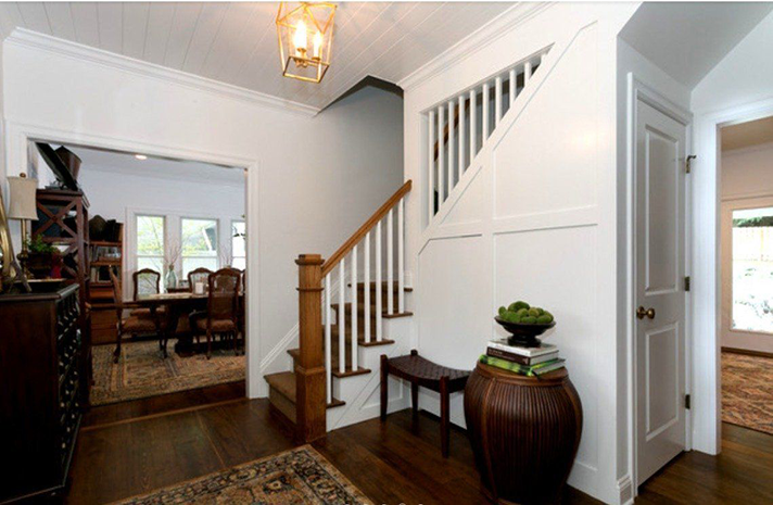 A hallway with stairs leading up to the second floor