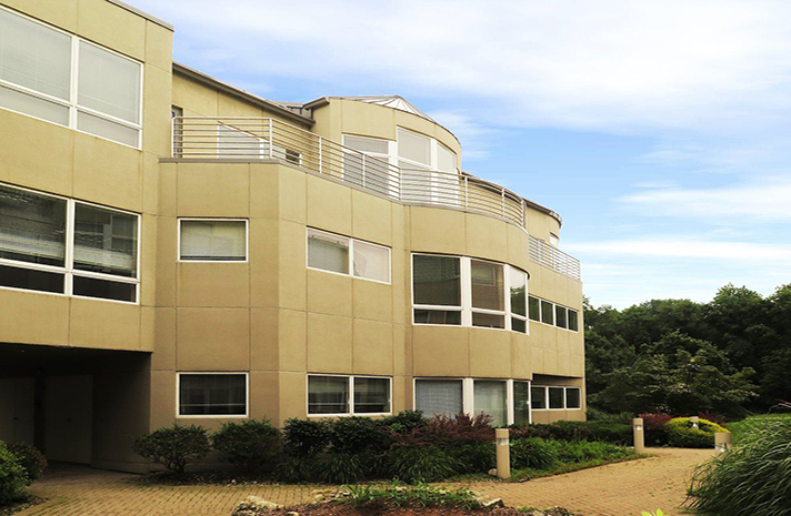 A large building with a lot of windows and a walkway leading to it