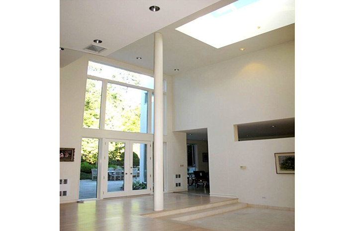 A large empty room with a skylight in the ceiling