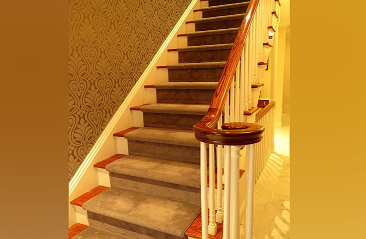 A staircase with carpeted steps and a wooden railing