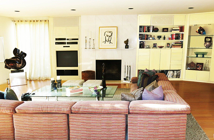 A living room with a pink couch and a fireplace