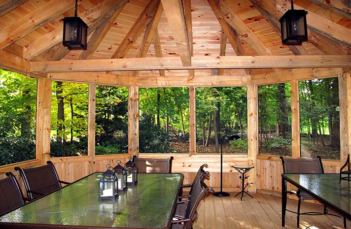 A screened in porch with a table and chairs