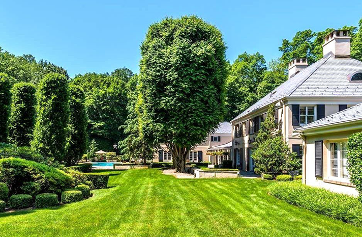 A large house with a lush green lawn in front of it.