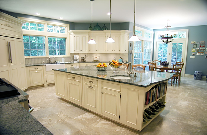 A kitchen with white cabinets and a large island in the middle.