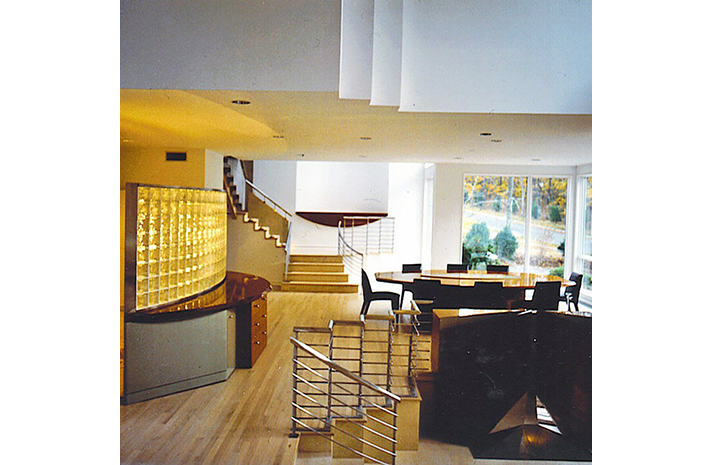 A living room with a staircase and a table and chairs