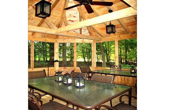 A gazebo with a table and chairs and a ceiling fan
