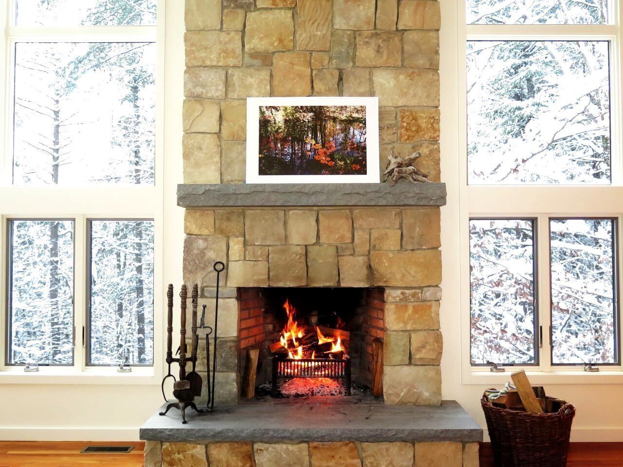 A fireplace with a picture on the wall above it