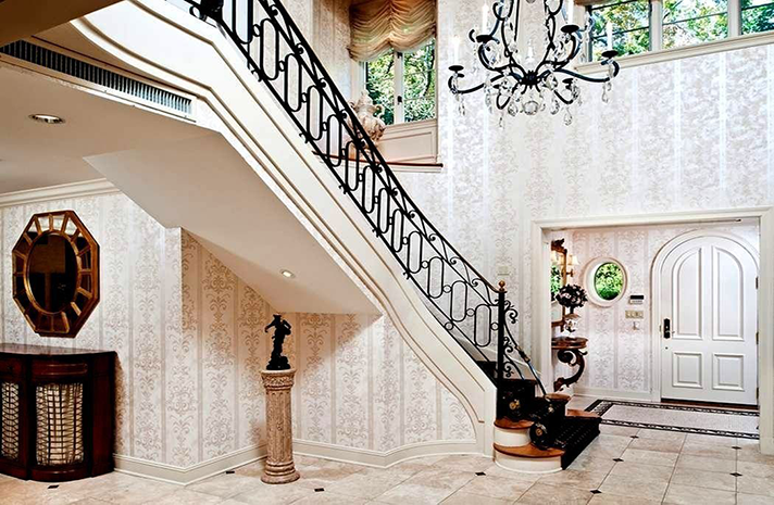 A large hallway with a staircase and a chandelier