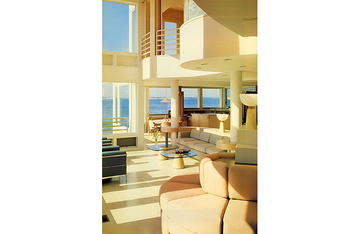 A living room with a lot of windows and a view of the ocean