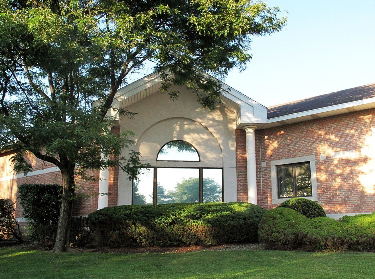 A large brick building with a tree in front of it