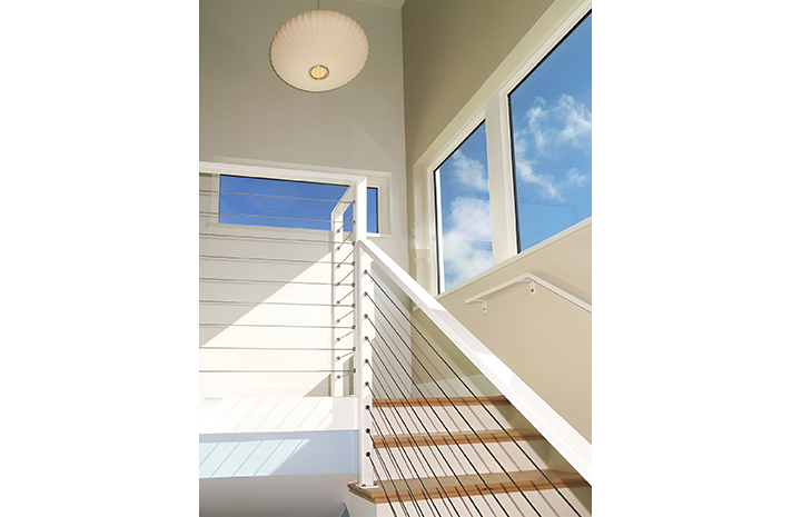 A white staircase with wooden steps and a stainless steel railing