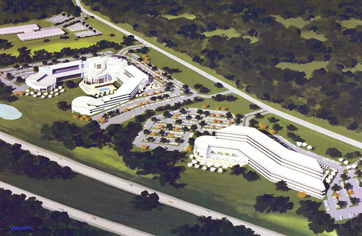 An aerial view of a large white building in the middle of a field