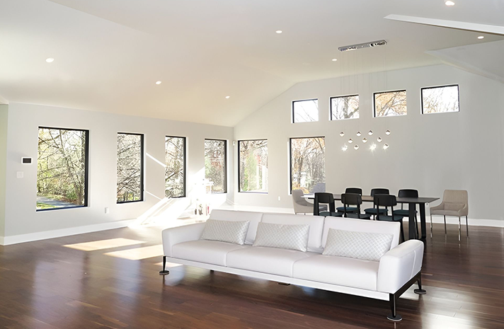 A living room with a white couch and a dining table