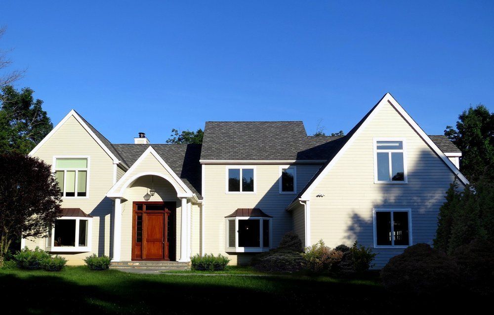 A large white house with a blue sky in the background