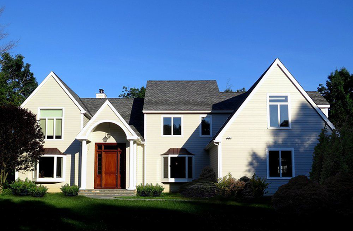 A large white house with a blue sky in the background