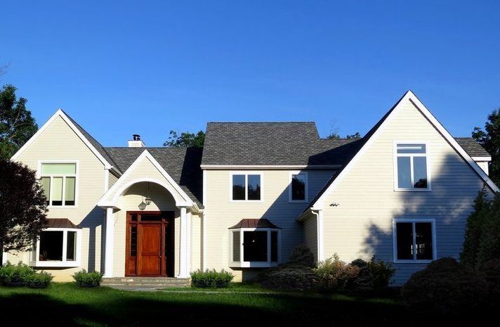 A large white house with a blue sky in the background