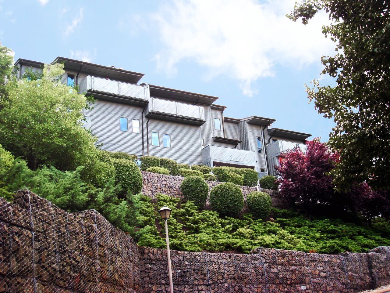 A building on a hill with trees and bushes around it