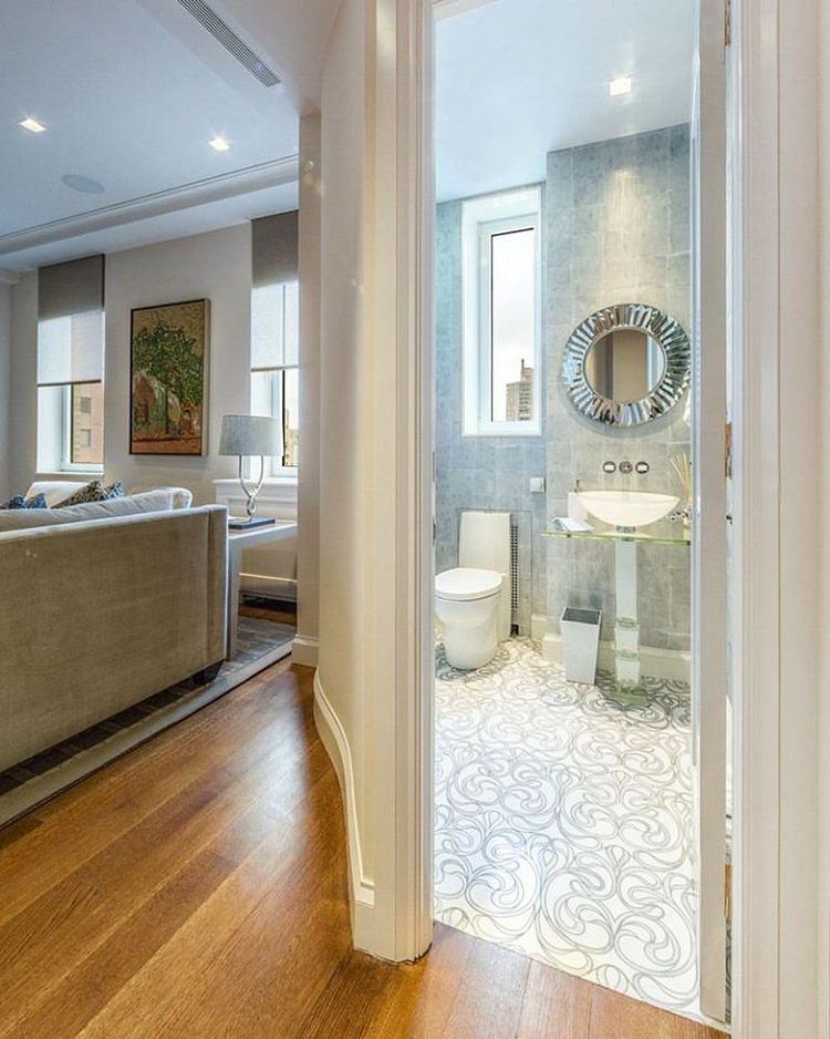 A bathroom with a toilet , sink and mirror