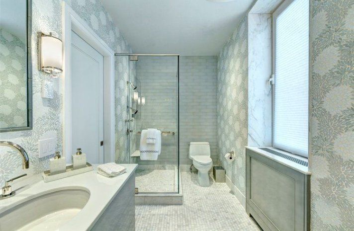 A bathroom with a sink , toilet , shower and window.