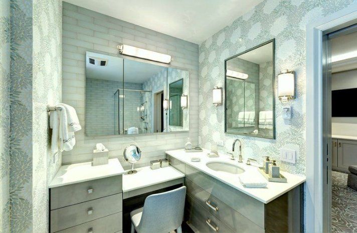 A bathroom with two sinks , a mirror and a desk.