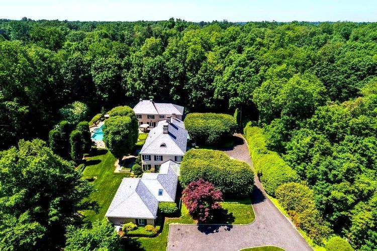 An aerial view of a house in the middle of a forest