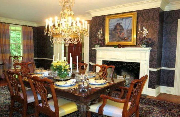 A dining room with a table and chairs and a fireplace