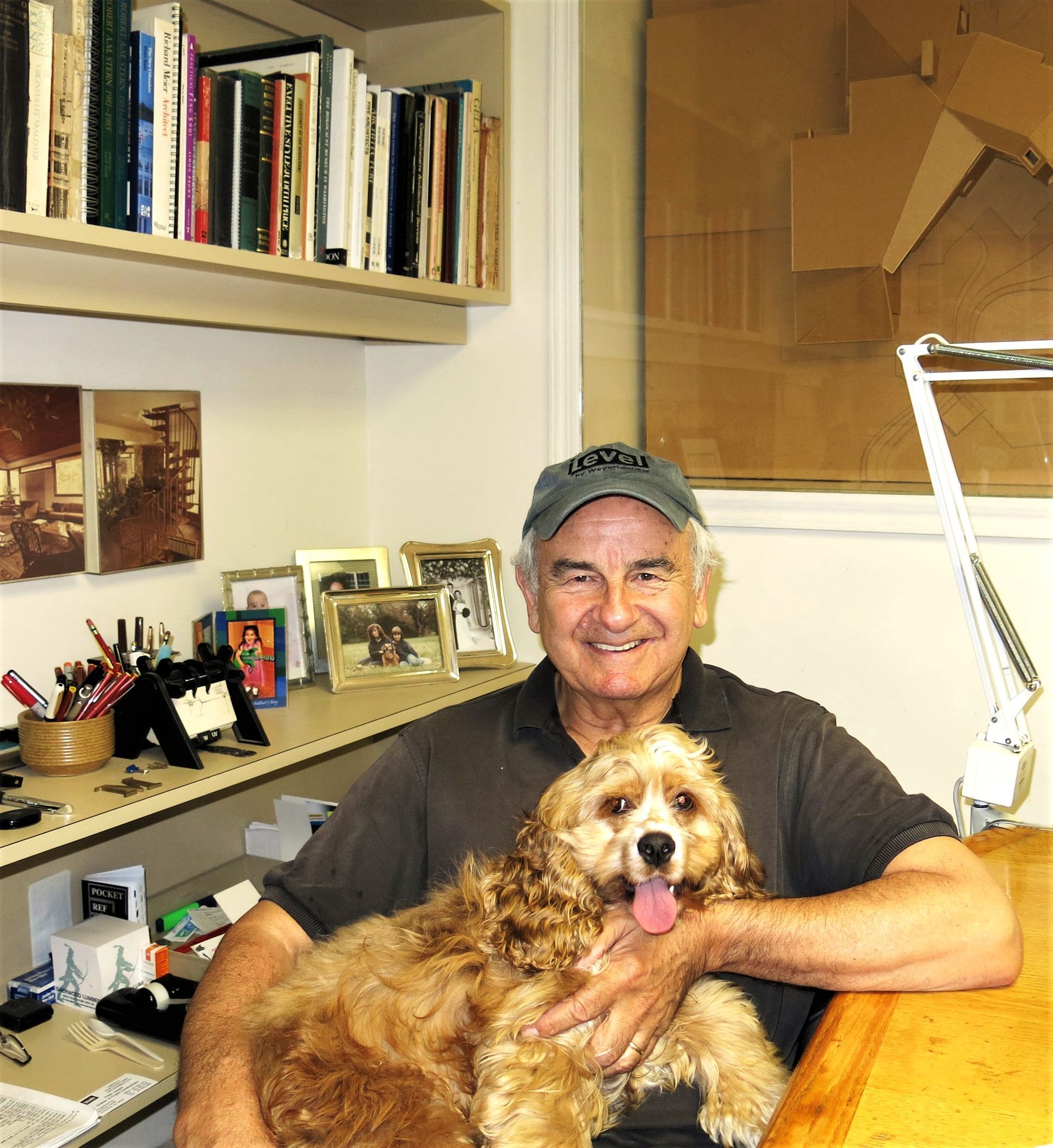 A man is sitting at a desk holding a dog