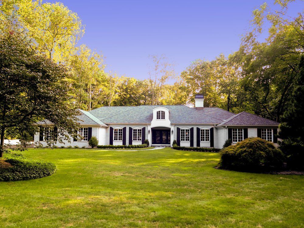 A large white house with a green roof and black shutters