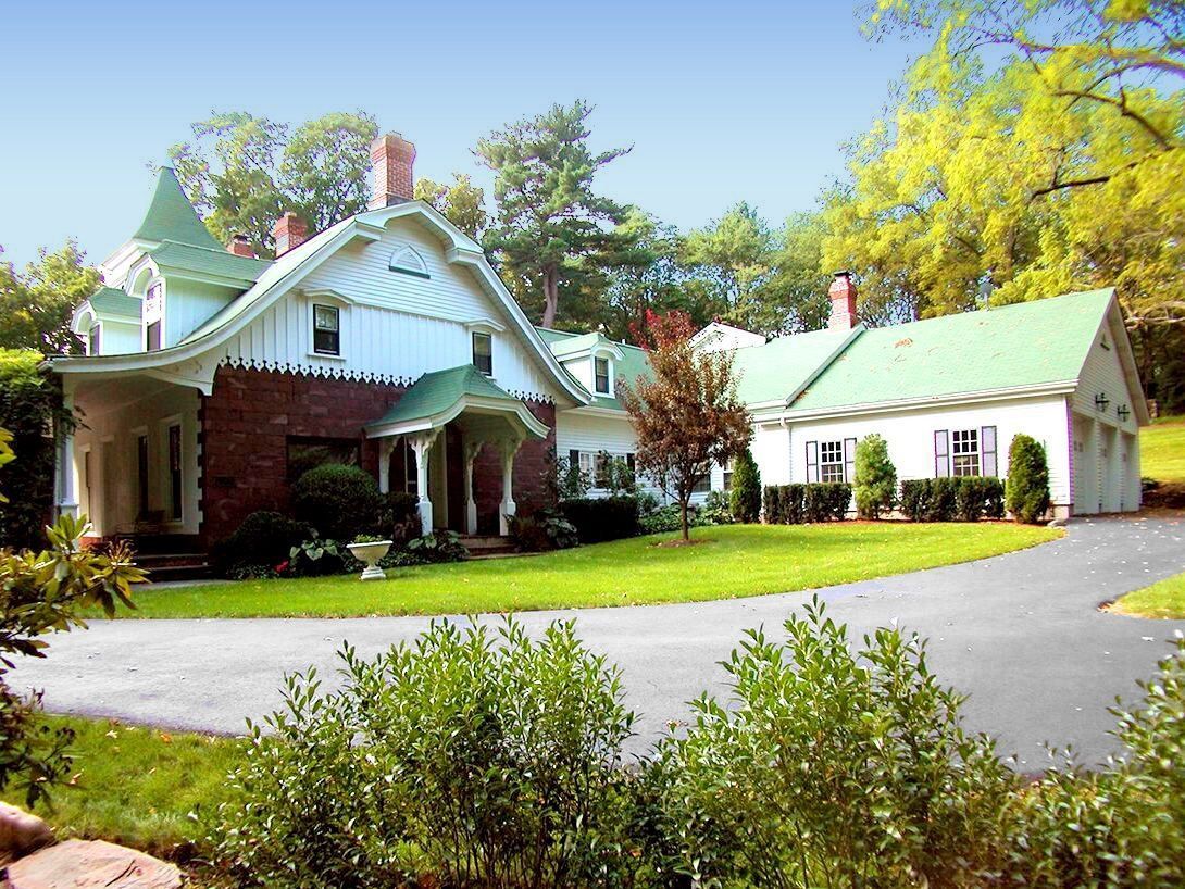 A large white house with a green roof