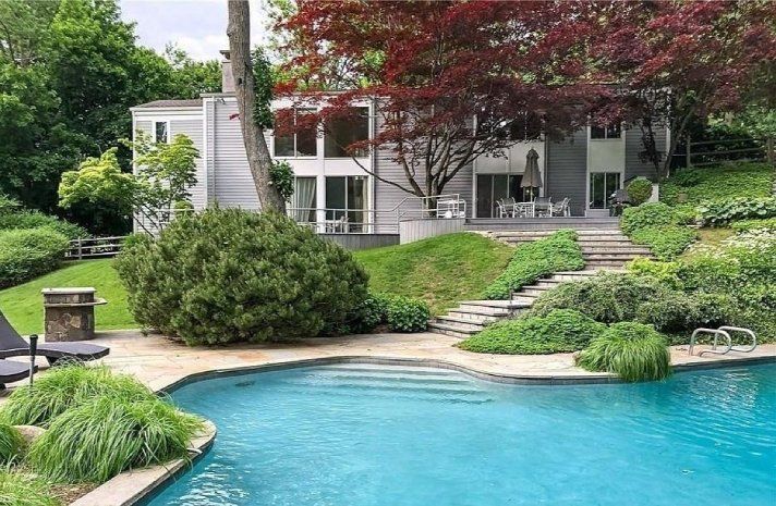 A large house with a swimming pool in front of it