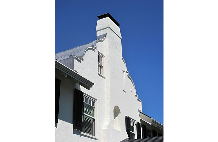A white building with a chimney on top of it