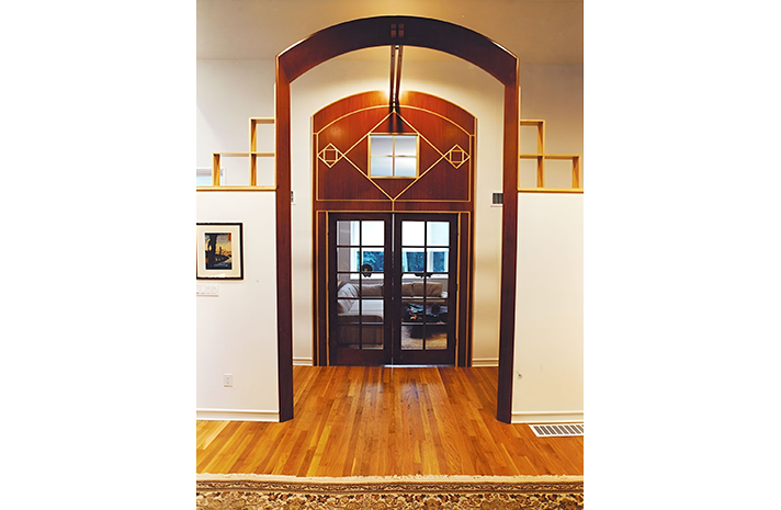 A living room with hardwood floors and arched doors