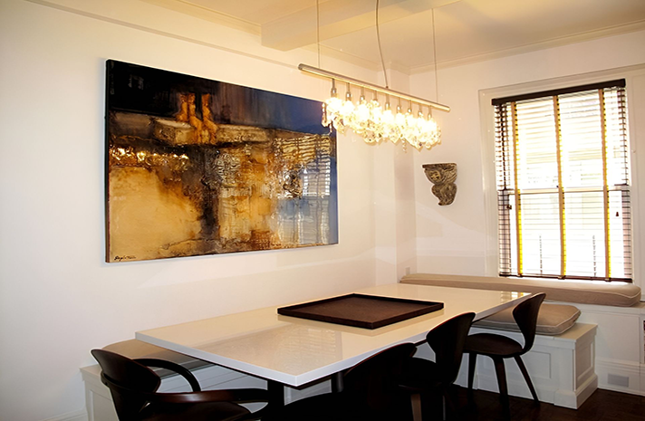 A dining room with a large painting on the wall above the table