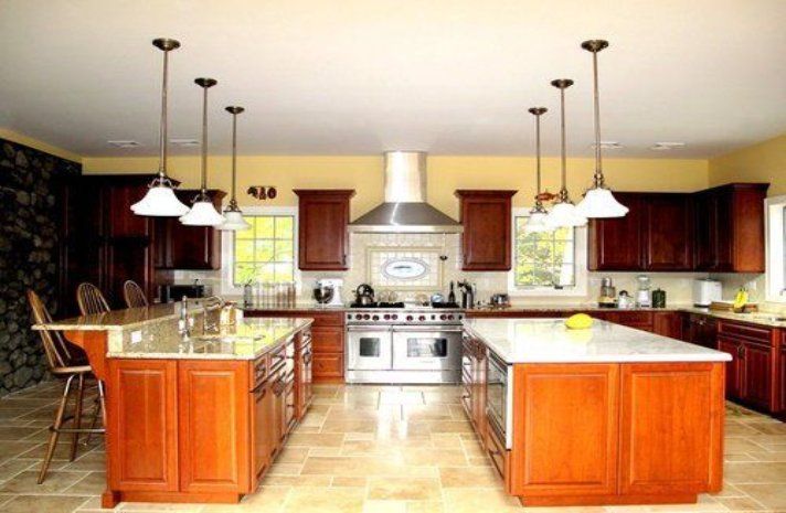 A large kitchen with two islands and stainless steel appliances