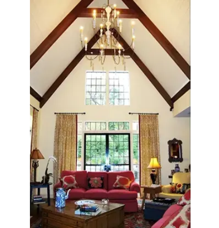 A living room with a red couch and a chandelier hanging from the ceiling