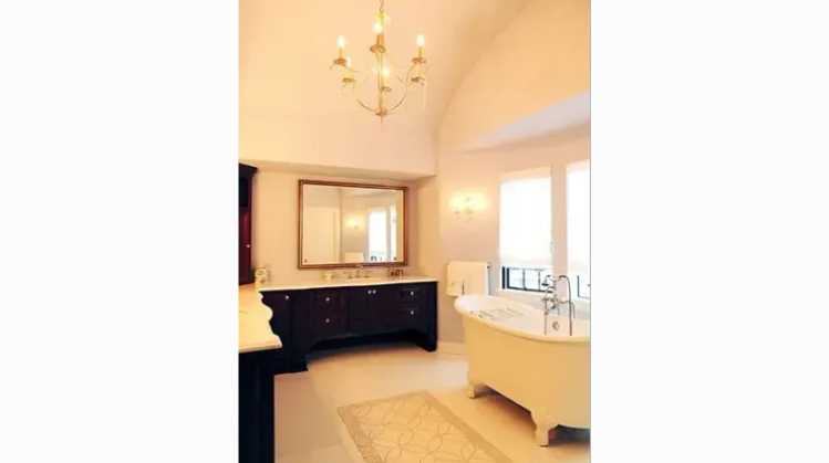 A bathroom with a bathtub and a chandelier hanging from the ceiling