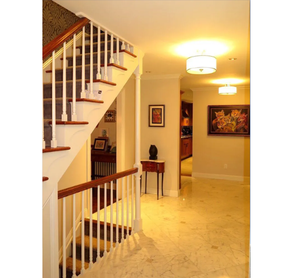 A hallway with stairs and a picture on the wall