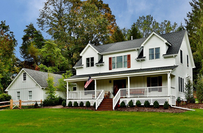 A large white house with a large porch and stairs