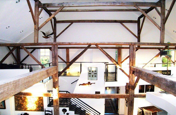 A large room with wooden beams and white walls